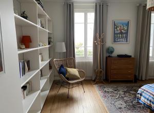 une pièce avec des étagères blanches, une chaise et une fenêtre dans l'établissement Gîte Avec Piscine La Petite Gironde, à Porchères