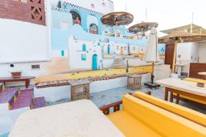 a room with tables and chairs and a building painted on the wall at Casa Nile View rooms - Nubian House in Aswan