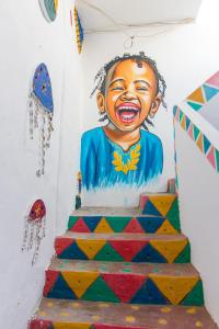 a cake with a painting of a child on a wall at Casa Nile View rooms - Nubian House in Aswan