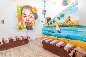 a room with a mural of a woman on the wall at Casa Nile View rooms - Nubian House in Aswan +33 photos