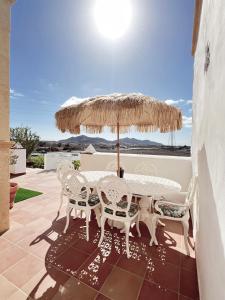 a table and chairs under an umbrella on a patio at Villa Petra in Tuineje