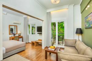 Una habitación de hotel con una cama y una sala de estar. en Pefka Hotel, en Tesalónica