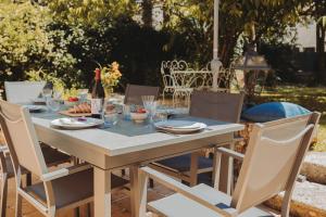einen Tisch mit Stühlen und eine Flasche Wein in der Unterkunft Maison coeur de Bastide-Piscine, ping pong & salle de jeux in Vianne