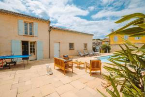 eine Terrasse mit einer Tischtennisplatte und Stühlen in der Unterkunft Maison coeur de Bastide-Piscine, ping pong & salle de jeux in Vianne