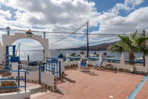 eine Terrasse mit Stühlen und Blick auf das Wasser in der Unterkunft Ventanas De Lanzarote in Playa Quemada