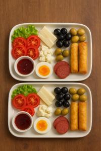 two trays of food with eggs tomatoes olives and cheese at Grand Cennet Beach Hotel in Akcay