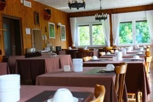 Un comedor con mesas y sillas y ventanas. en Sporting Hotel Club, en Pelos