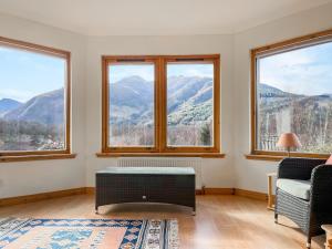 ein Wohnzimmer mit Fenstern und Bergblick in der Unterkunft Nether Carness in North Ballachulish