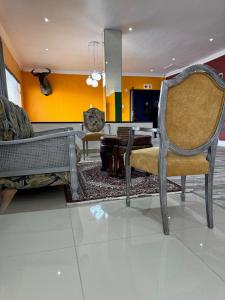 a living room with a chair and a table at Pro Max Guesthouse Goodwood in Goodwood
