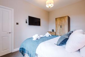 een slaapkamer met een bed met twee knuffels erop bij Charming family home in Heaton Norris +42 foto's