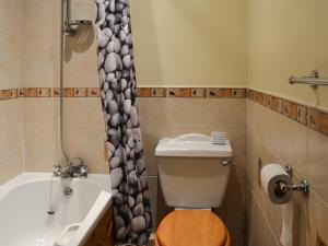 a bathroom with a toilet and a tub and a sink at Bramble Cottage-19878 in Cloughton +5 photos