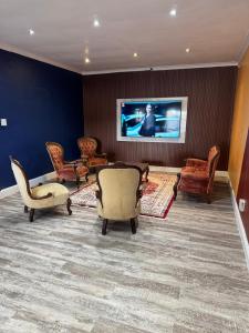 a living room with chairs and a flat screen tv at Pro Max Guesthouse Goodwood in Goodwood