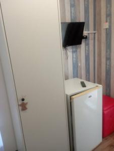 a room with a small refrigerator and a tv on the wall at Tony Hotel in Nicosia