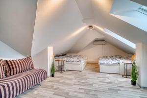 a attic room with two beds and a couch at CitySpace Košická in Nivy