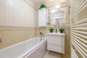 a bathroom with a tub and a sink and a mirror at CitySpace Košická in Nivy +20 photos