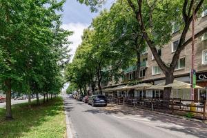 a street with trees and cars parked next to a building at CitySpace Košická in Nivy
