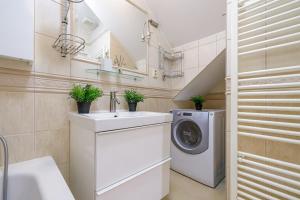 a bathroom with a washing machine and a sink at CitySpace Košická in Nivy