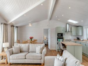 a living room with a couch and a kitchen at Fuchsia Lodge in Willington