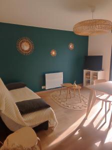 a living room with a bed and a green wall at Appartement à la campagne in Saint-Georges-de-Luzençon