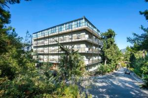 Un edificio alto con árboles delante. en Pefka Hotel, en Tesalónica