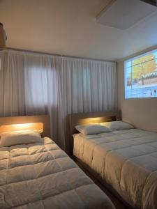 Un dormitorio con dos camas y una gran ventana. en Exit 4 of Hongik University, en Samgong-ni