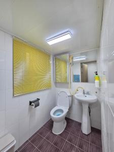 un baño con inodoro y lavabo en Exit 4 of Hongik University, en Samgong-ni