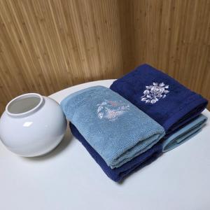 una pila de toallas y un jarrón sobre una mesa en Exit 4 of Hongik University, en Samgong-ni