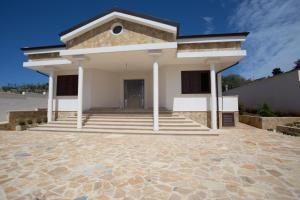 a large white house with a stone driveway at B&B Cesaranum in Casarano