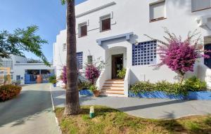ein weißes Gebäude mit rosa Blumen davor in der Unterkunft 3 Bedroom Cozy Home In Islantilla - Isla Cris in Islantilla + 19 Fotos