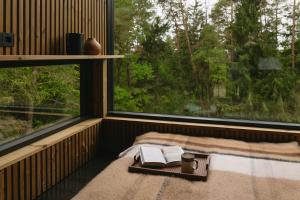 een kamer met een bed met twee boeken en een raam bij Blackview cabin in Kulautuva +8 foto's