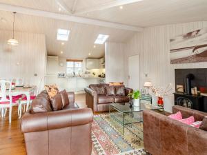 a living room with leather furniture and a table at Beech Tree Lodge in Willington +36 photos