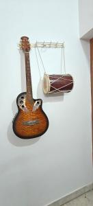 uma guitarra pendurada na parede com uma bateria em The Duplex House HSR em Bangalore