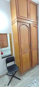 uma cadeira preta sentada ao lado de um armário de madeira em The Duplex House HSR em Bangalore