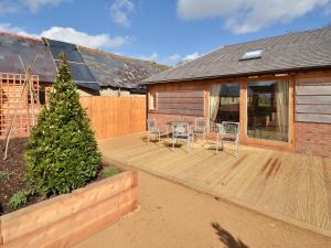 eine Holzterrasse mit Stühlen und ein Haus in der Unterkunft Little Barn - Ukc2539 in Fordingbridge