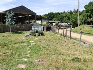 einen Hof mit einem Holzzaun und einem Gebäude in der Unterkunft Little Barn - Ukc2539 in Fordingbridge + 9 Fotos