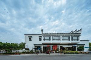 un grand bâtiment blanc avec beaucoup de fenêtres dans l'établissement Huazhu Luxury Niushou Yinlan Homestay, à Sanbanqiao 67 autres photos