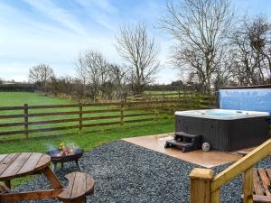 Un patio trasero con jacuzzi y parrilla. en Greengill Farm Shepherds Hut- Ukc3632, en Gilcrux