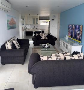 ダーバンにあるSea Lodge G01のリビングルーム(ソファ2台付)、キッチンが備わります。