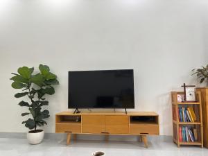 - une télévision sur un support en bois dans le salon dans l'établissement Nhà mình Homestay, à Ấp Thanh Sơn (1) 4 autres photos