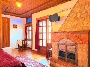 a living room with a stone fireplace with a table at Kaf Dagi Konak Hotel in Rize