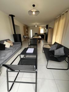 sala de estar con varias sillas y sofá en Gîte neuf, à 12mn du Futuroscope, à la campagne-Le Coquelicot, en Saint-Léger