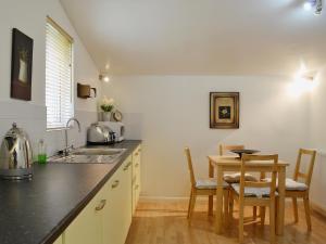 a kitchen with a table and a small table and chairs at High Moor Cottage in Dufton