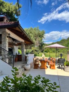 a patio with a table and chairs and an umbrella at Apartment Potocnica 222d in Novalja