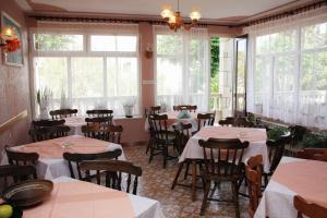 a dining room with tables and chairs and windows at Apartments by the sea Barbat, Rab - 4993 in Barbat na Rabu