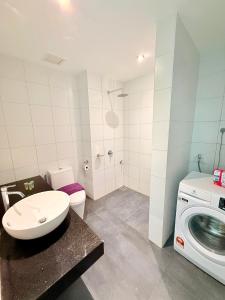 a bathroom with a toilet sink and a washing machine at Chambers Suites Mrk in Kuala Lumpur