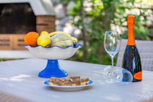 eine Schale Obst auf einem Tisch mit einer Flasche Wein in der Unterkunft Apartments by the sea Klenovica, Novi Vinodolski - 5575 in Klenovica + 32 Fotos