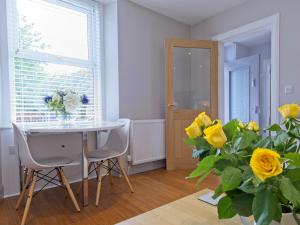 comedor con mesa y jarrón de rosas amarillas en Lower Canterbury House, en Gattonside 22 fotos más