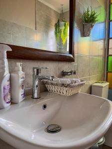 ein Waschbecken mit einem Spiegel und einem Korb darauf in der Unterkunft Wild Amboseli Ndovu Cottage. in Amboseli-Nationalpark