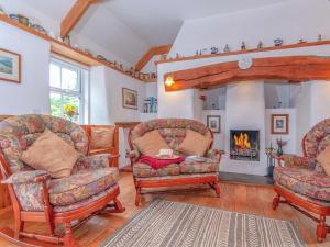 ein Wohnzimmer mit zwei Stühlen und einem Kamin in der Unterkunft Inglenook Cottage in Landshipping