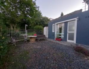 a blue house with a bench and a table at Alojamiento Temporario El Nogal in Tandil